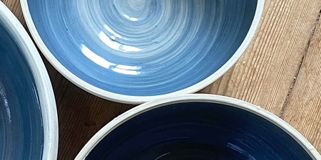 Tre blå keramikskålar på ett trägolv med texten 'Prova på: Keramik' ovanpå.