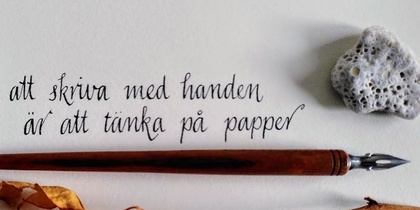 En handskriven svensk text på papper med en gammal bläckpenna, en torkad ros och en sten bredvid.