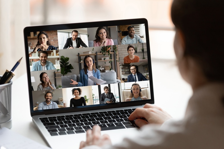 Person deltar i ett videomöte på en bärbar dator med flera deltagare synliga på skärmen.