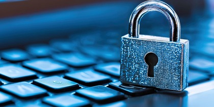 Ett silverfärgat hänglås står på ett svart tangentbord, symboliserar datasäkerhet.