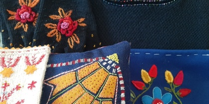 Närbild av färgglada broderade textilier med blommönster i olika färger och stilar.