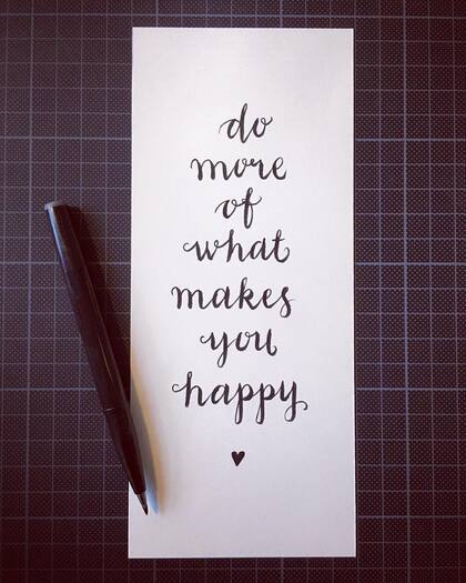 Handskriven text på ett vitt papper: 'do more of what makes you happy', med en svart penna bredvid.