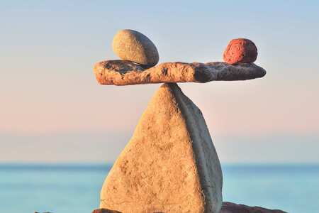 Tre stenar balanserar på en stor spetsig sten.