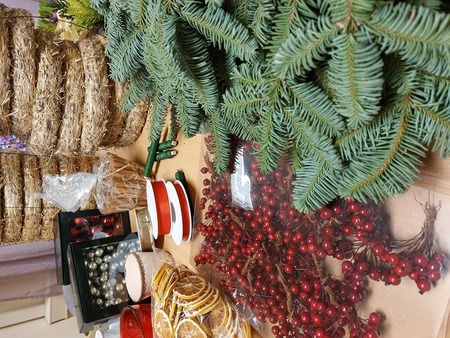 Material för att göra julkransar, inklusive granris, halmstommar, röda bär, torkade apelsiner, kanelstänger och julkulor.