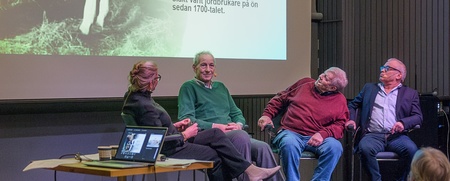 Fyra personer sitter på scen och samtalar inför publik, med en bild och text om Tjörns sista mjölkbonde projicerad bakom dem.