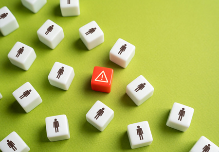 Vita kuber med symboler av människor omger en röd kub med en varningssymbol på grön bakgrund.
