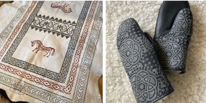 Tre handgjorda textilier: tovade tofflor, broderad duk och stickade vantar på vit matta.