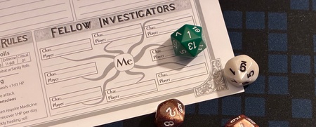 Flera tärningar och ett rollformulär för rollspel ligger på ett rutigt spelbord.