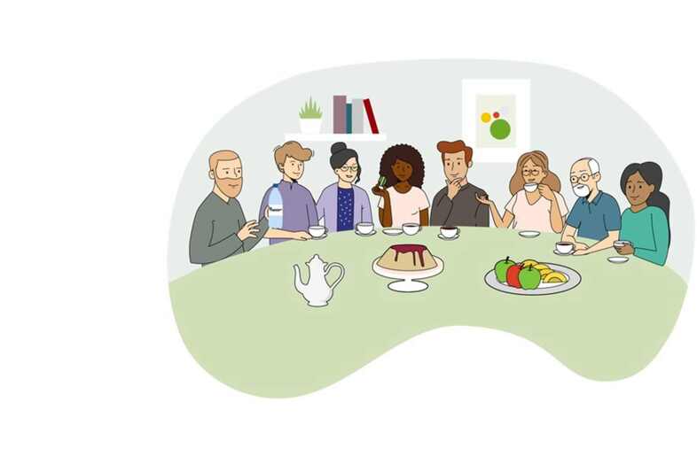 Åtta personer sitter vid ett bord och fikar.