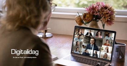 Person deltar i videomöte på laptop vid skrivbord med blommor och fönster i bakgrunden.