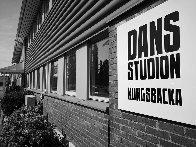 Svartvit bild på en byggnad med en skylt som säger 'Dansstudion Kungsbacka'.