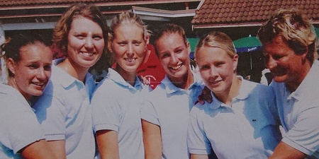 En grupp personer i vita kläder håller tillsammans i en pokal utomhus.