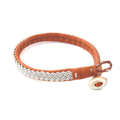 Brunt armband i läder med flätat silvermönster och knappstängning.