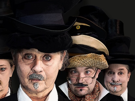 Fem personer med teaterlik sminkning och olika hattar står tätt tillsammans och tittar in i kameran.