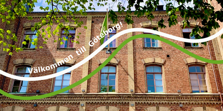 Tegelbyggnad med stora fönster, gröna trädgrenar och texten 'Välkommen till Göteborg!'.