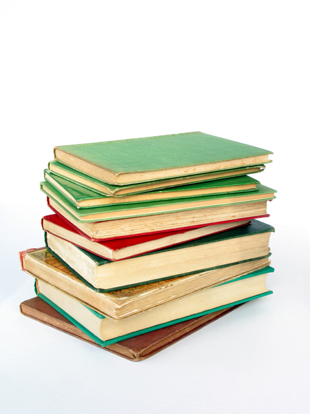 En stapel med åtta inbundna böcker i olika färger ligger på varandra mot vit bakgrund.