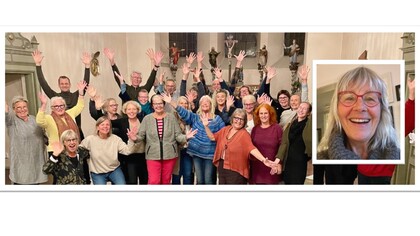 En grupp människor står i ett rum med händerna uppsträckta, glada och sociala.