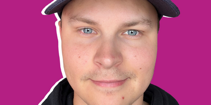 Närbild på en ung man med keps där det står 'Creative Director', svart hoodie och lila bakgrund.