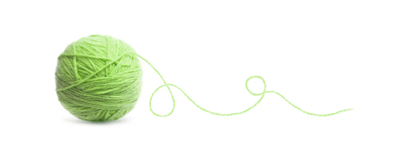 Ett nystan av ljusgrönt garn med en lös tråd på vit bakgrund.