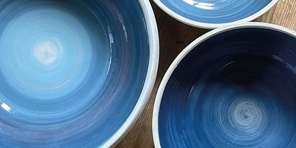 Tre blå keramikskålar på ett trägolv med texten 'Prova på: Keramik' i hörnet.