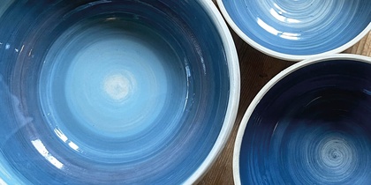 Tre blå keramikskålar på ett trägolv med texten 'Prova på: Keramik' i hörnet.