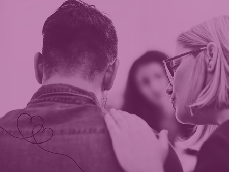 En person lägger en hand på en annans axel i en stödjande gest, med en tredje person i bakgrunden.