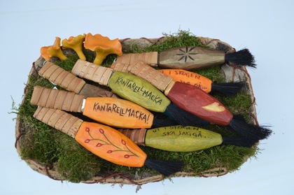 Handgjorda svampborstar av trä och björknäver, dekorerade och lagda på mossa med kantareller.