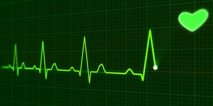 Grön EKG-kurva på svart bakgrund med ett lysande hjärta i övre högra hörnet.