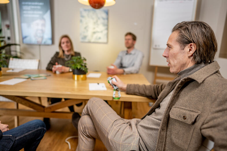 Några personer sitter runt ett bord och diskuterar.