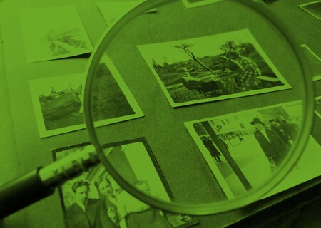 Ett förstoringsglas fokuserar på ett fotoalbum.