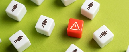Vita kuber med symboler av människor omger en röd kub med en varningssymbol på grön bakgrund.