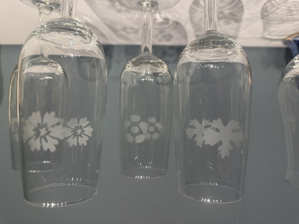 Fyra champagneglas med frostade blommönster står på ett vitt underlag.