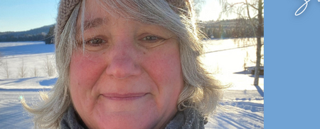 Kvinna med mössa och halsduk utomhus i vintrigt landskap, med jul- och nyårshälsning på svenska.