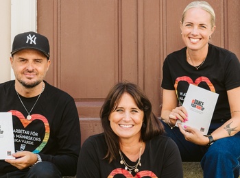 Tre personer sitter på en trappa utomhus och håller böcker med texten 'DANCE YOUR WAY'.