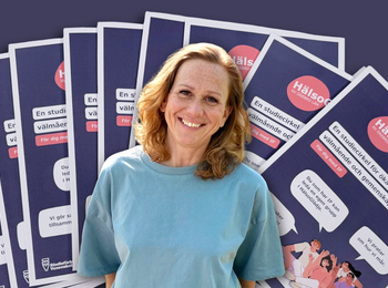 En person i blå tröja står framför flera informationsblad om en studiecirkel för ökat välmående.