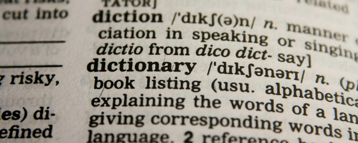 Närbild av en ordbokssida med ordet 'dictionary' och dess definition tydligt synlig.