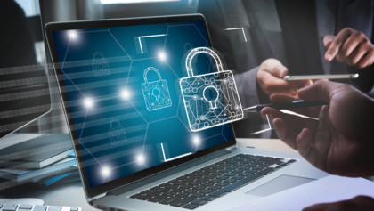 En bärbar dator med digitala låsikoner på skärmen, personer arbetar i bakgrunden.