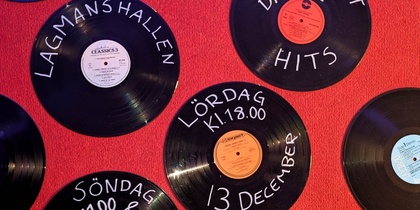Svarta vinylskivor med vit text om ett dansevenemang på röd matta. Information om datum, plats och biljettköp.