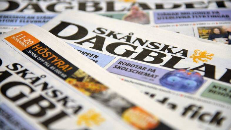 Flera exemplar av den svenska dagstidningen Skånska Dagbladet ligger utspridda.