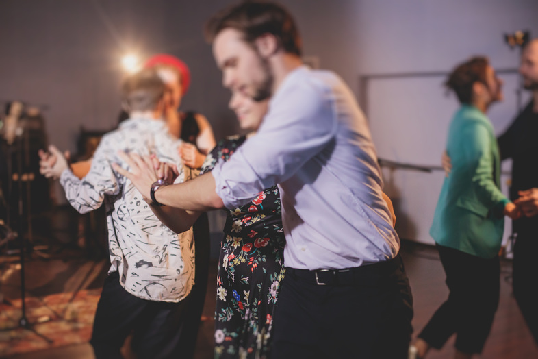 En grupp människor dansar tillsammans i ett rum med dämpad belysning.