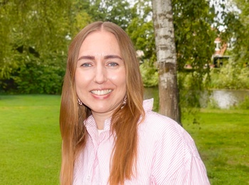 Porträtt på Cecilia, projektledare på SV Örebro län. Hon står utomhus, grön gräsmatta i bakgrunden, på sig har hon en röd- och vitrandig skjorta.