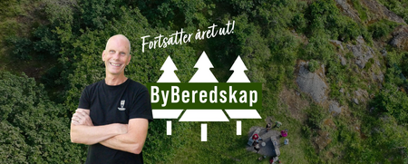 Man ler framför en skogsbakgrund med texten 'Fortsätter året ut! ByBeredskap' och en illustration av tre granar.