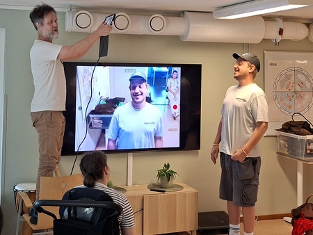 En pedagog filmar en deltagare och en person tittar på