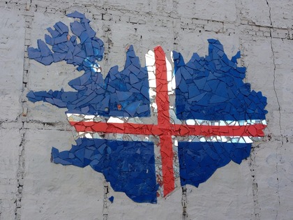 Mosaik av Islands karta med Islands flagga målad på en vit vägg.