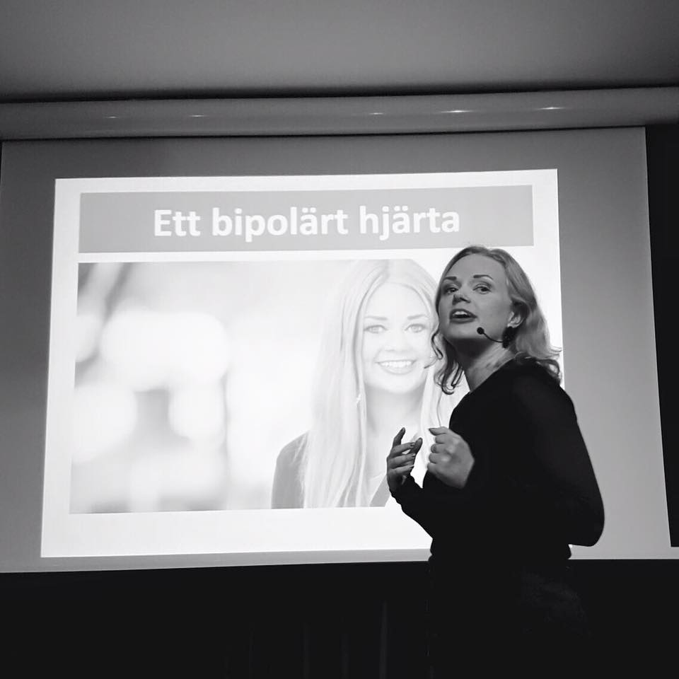 En person håller en presentation framför en projektor med texten 'Ett bipolärt hjärta'.