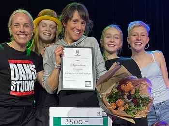 En grupp glada och unga personer som håller ett diplom och blombukett