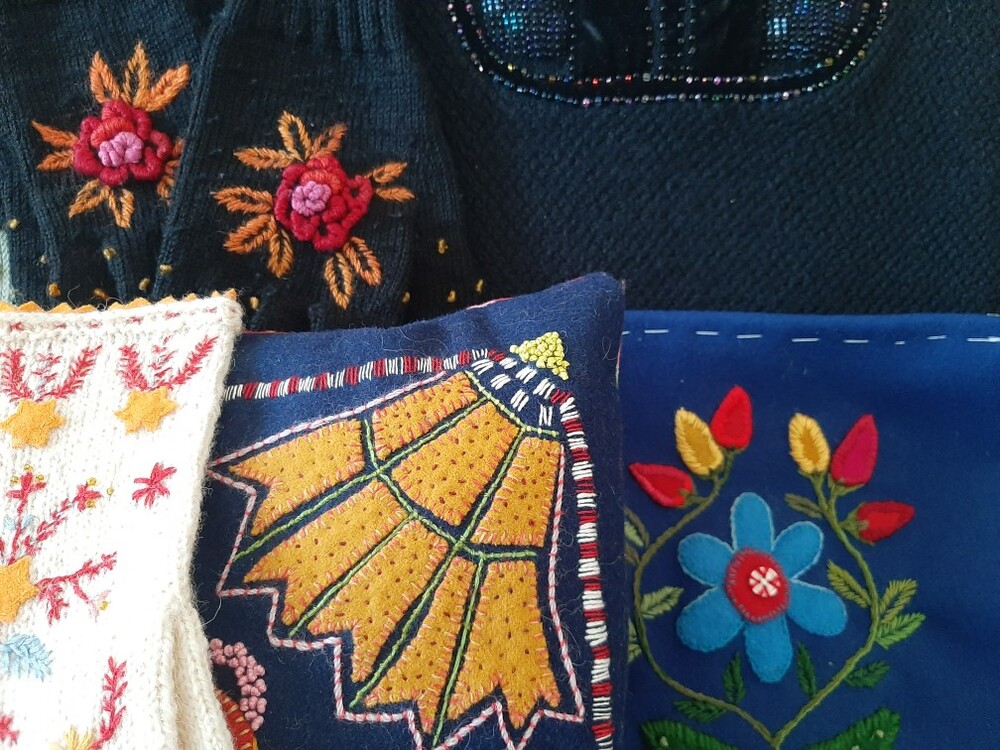 Närbild av färgglada broderade textilier med blommönster i olika färger och stilar.