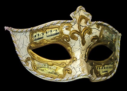 Venetiansk mask i vitt och guld med noter och målade motiv, mot svart bakgrund.
