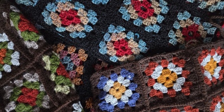 Närbild av färgglada virkade mormorsrutor i olika färger och mönster.