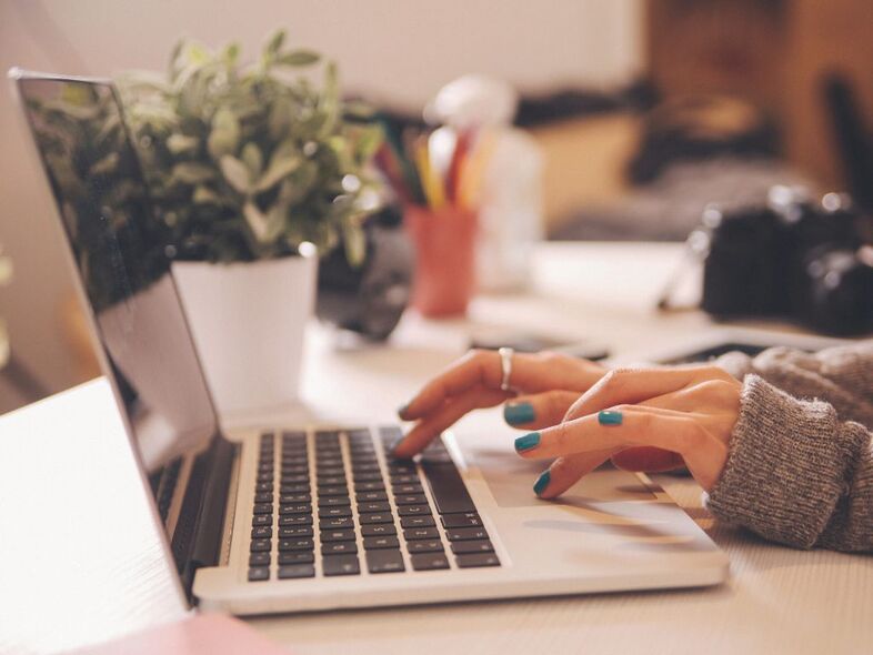 Två händer skriver på en laptop.